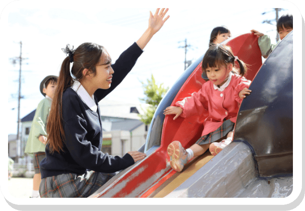 すべり台で遊ぶ園児と先生の様子